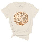 Christian t-shirt with “Made for More” in handwritten script surrounded by flowers and plants; soft cotton unisex tee symbolizing faith, growth, and divine purpose.