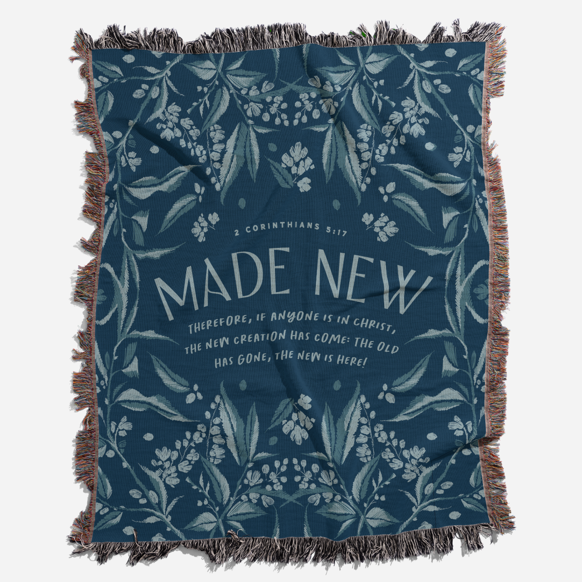 Blue blanket with floral pattern and 'Made New' text on a white background