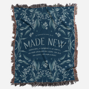 Blue blanket with floral pattern and 'Made New' text on a white background