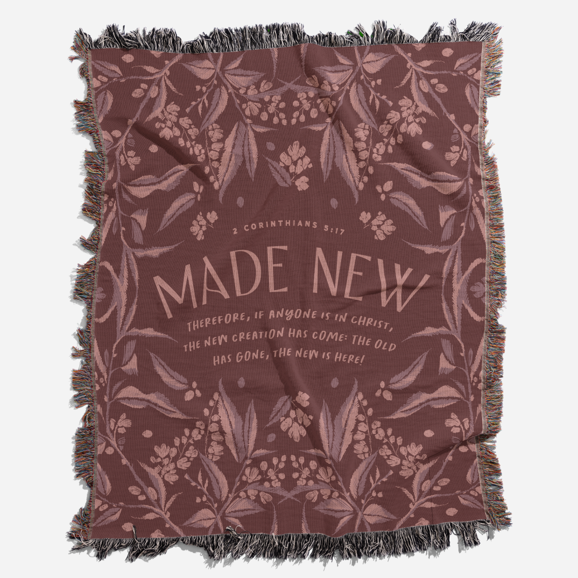 Blanket with floral pattern and 'Made New' text on a white background