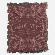 Blanket with floral pattern and 'Made New' text on a white background
