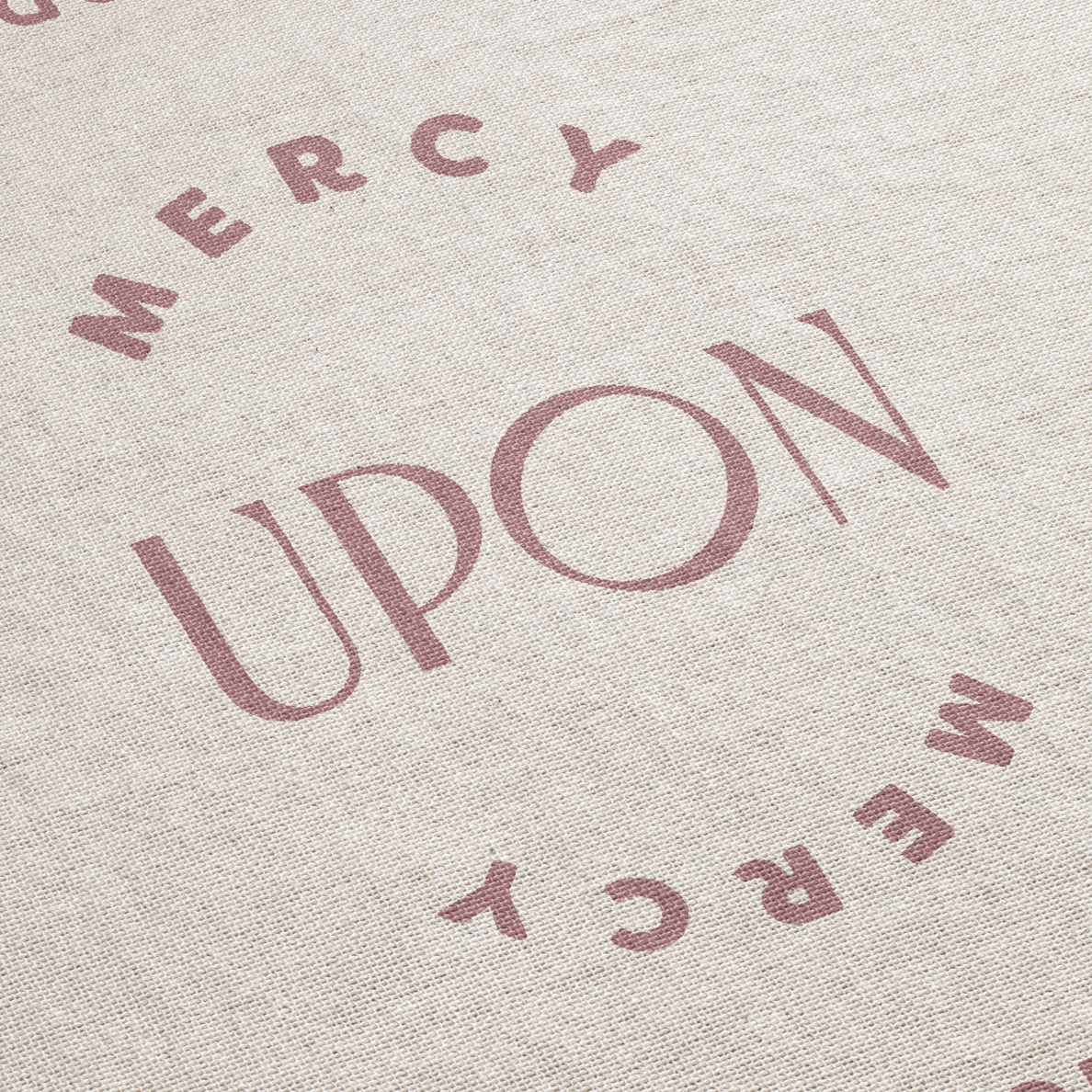 Text 'MERCY UPON MERCY' printed on a textured fabric background