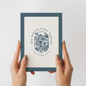 Framed print with floral design and text held by hands against a light background