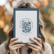 Person holding a book titled 'New Mercies Every Morning' with a floral design against a blurred natural background.