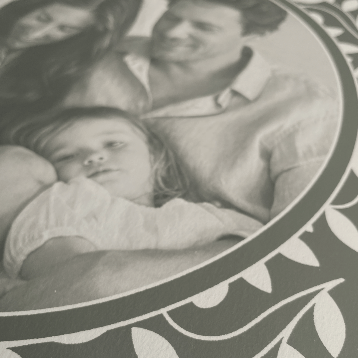 Black and white photo of a family with a decorative border