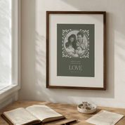 Framed family photo with 'LOVE' text on a wall above a desk with books and a bowl.