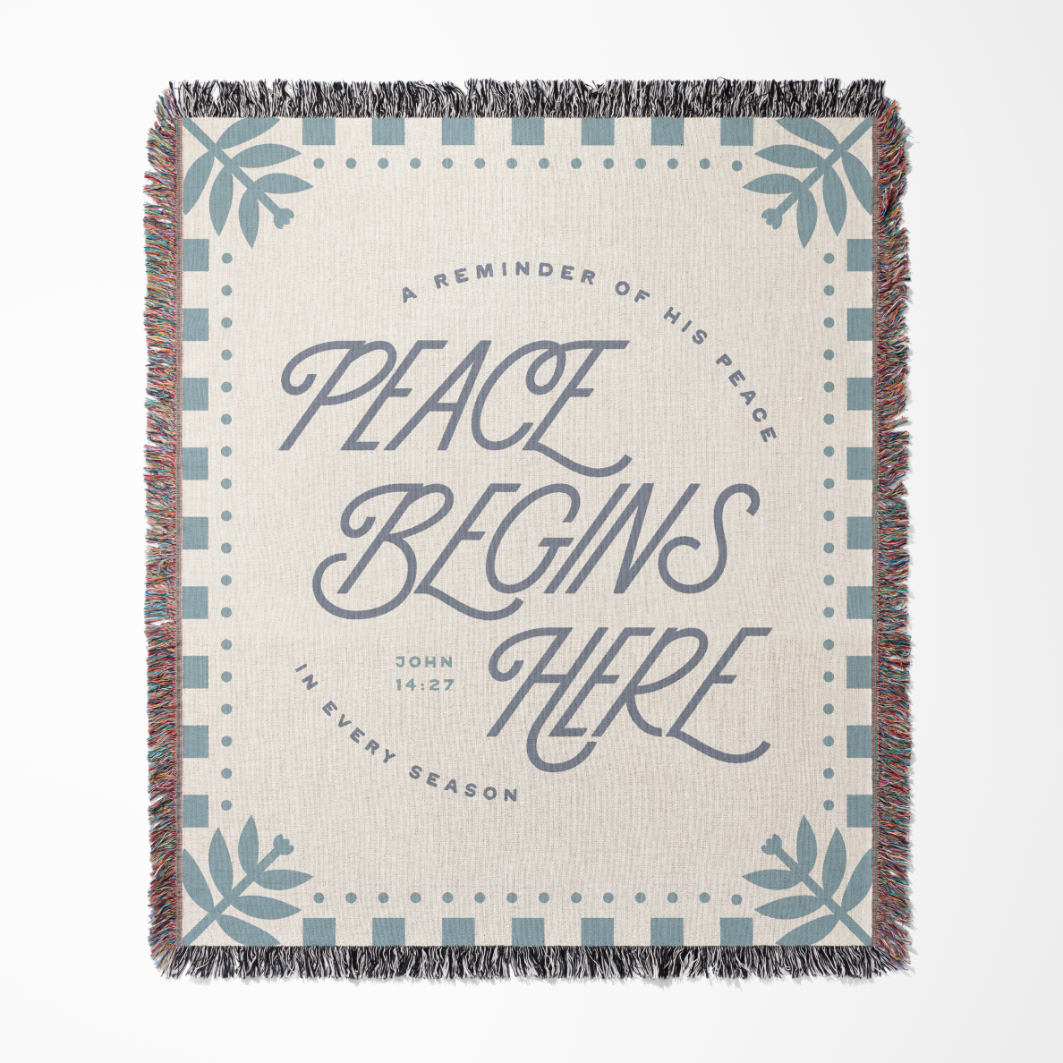 Blanket with 'Peace Begins Here' text and decorative patterns on a white background