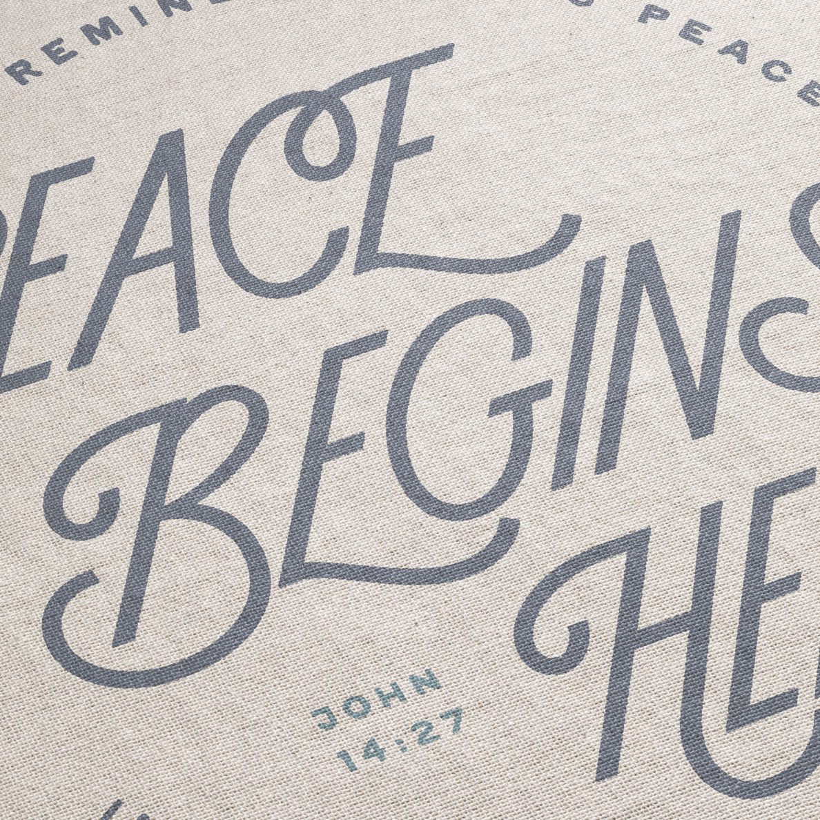 Text on fabric with 'Peace Begins Here' and 'John 14:27' printed in gray.