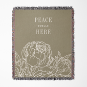 Blanket with floral design and 'Peace Dwell Here' text on a beige background