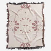 Blanket with 'Peace Upon Peace' text and floral design on a beige background