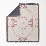 Blanket with 'Peace Upon Peace' text and decorative design on a white background