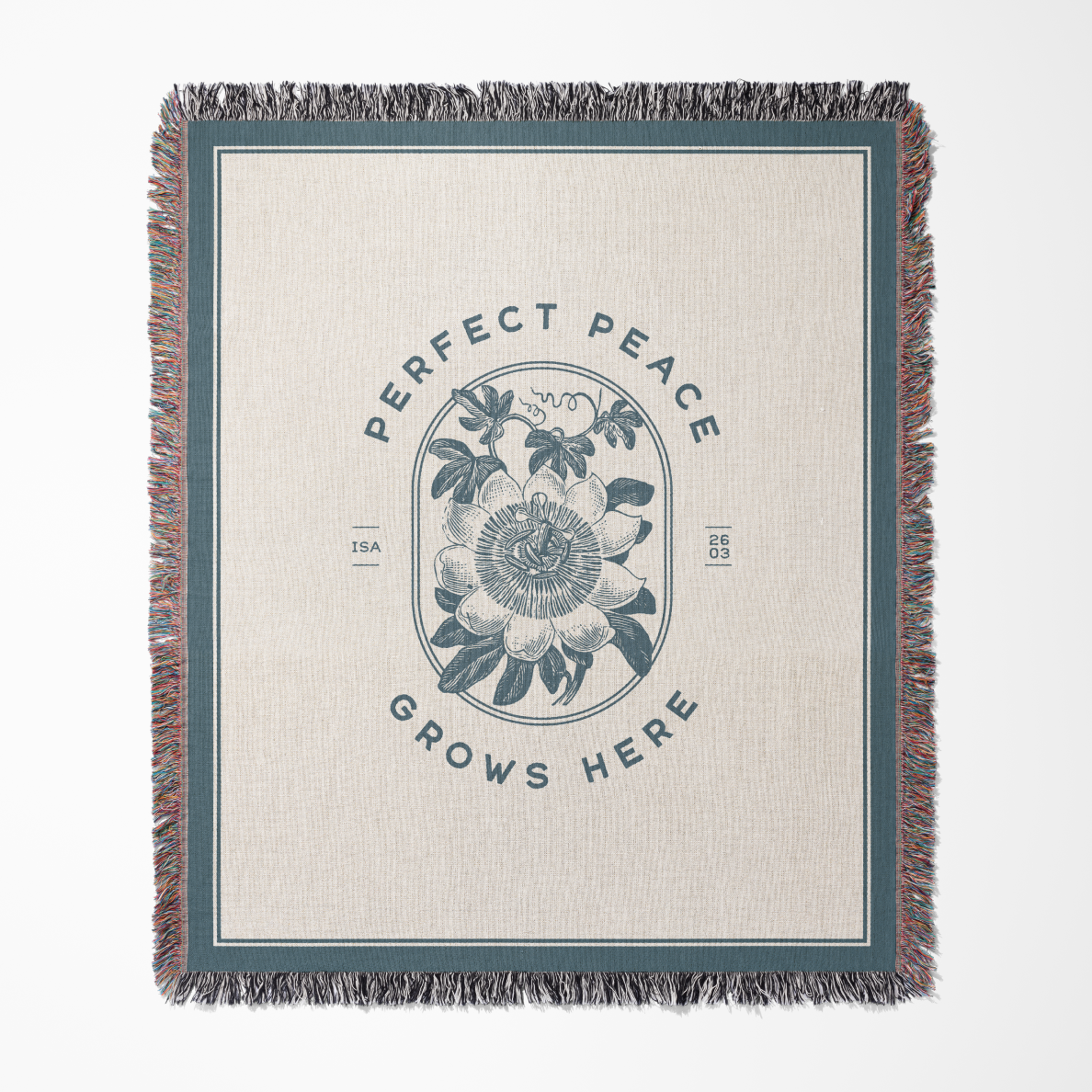 Blanket with floral design and 'Perfect Peace Grows Here' text on a beige background