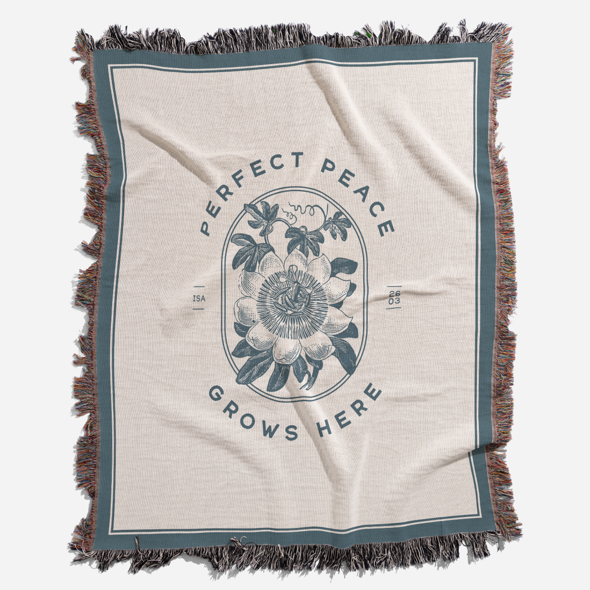 Blanket with floral design and text 'Perfect Peace Grows Here' on a white background