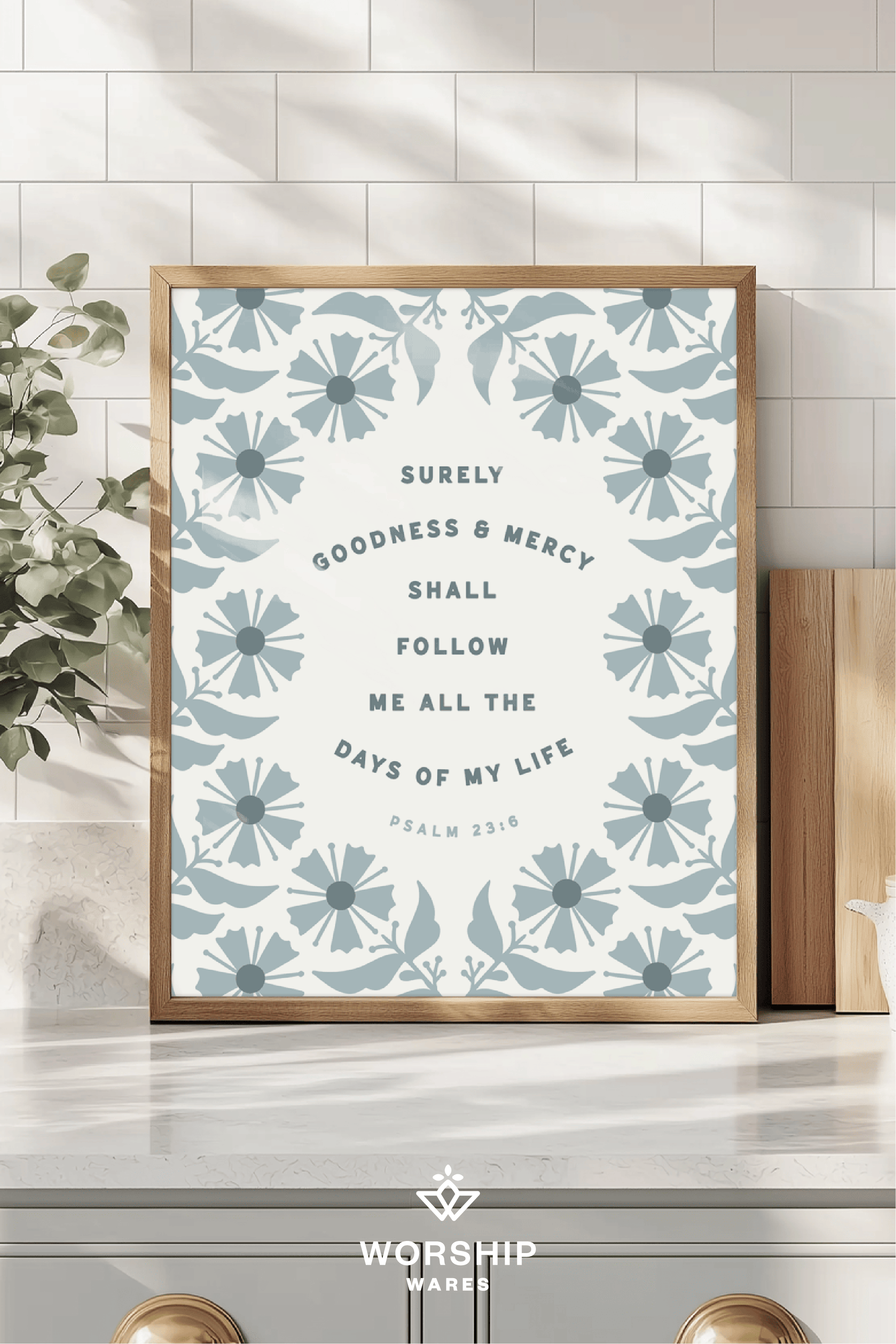 Framed artwork with floral design and text on a wall, featuring the brand 'Worship Wares'.