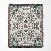 Christian throw blanket with garden-inspired folk art design and the phrase 'Praise God from whom all blessings flow' in soft cottage colors