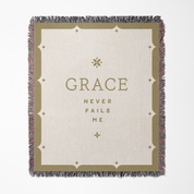 Blanket with 'GRACE NEVER FAILS ME' text on a white background