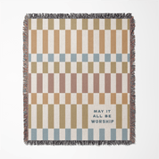 Checkered blanket with text 'May it all be worship' on a white background