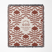 Decorative throw blanket with floral pattern and text on a white background