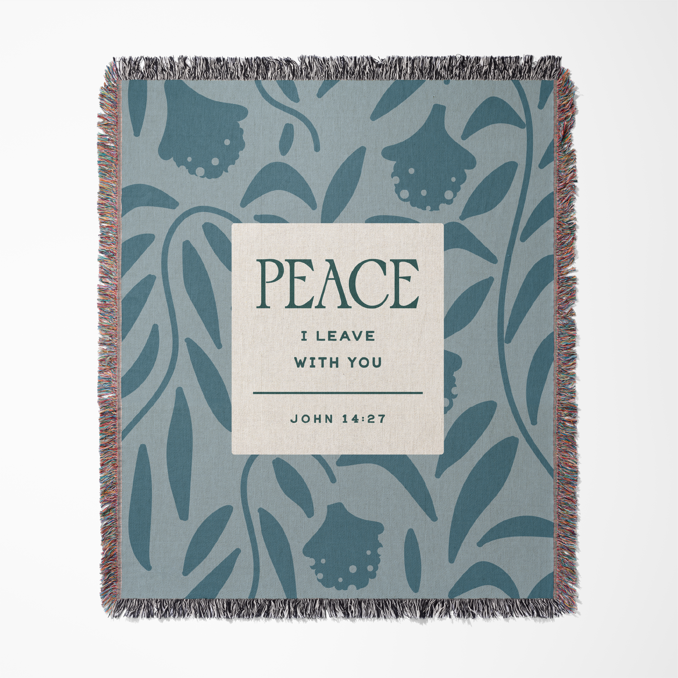 Woven blanket with leaf pattern and 'Peace I Leave With You' text on a white background