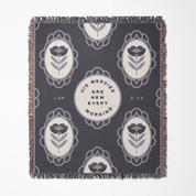 Decorative throw blanket with floral patterns and text on a blue background