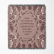 Decorative blanket with floral design and inspirational quote on a beige background