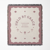 Blanket with 'Held by Grace' text on a white background