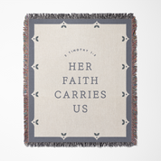 Blanket with 'Her Faith Carries Us' text and decorative border on a white background