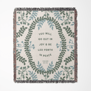 Decorative throw blanket with leaf pattern and inspirational quote on a white background