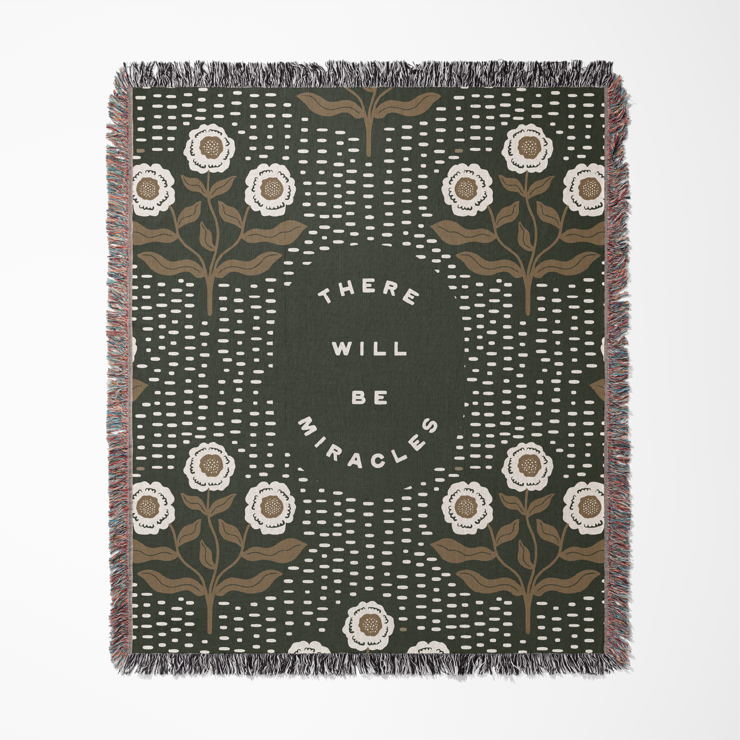 Decorative throw blanket with floral patterns and 'There Will Be Miracles' text on a green background.
