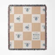 Checkered blanket with bee patterns and a central text block on a white background