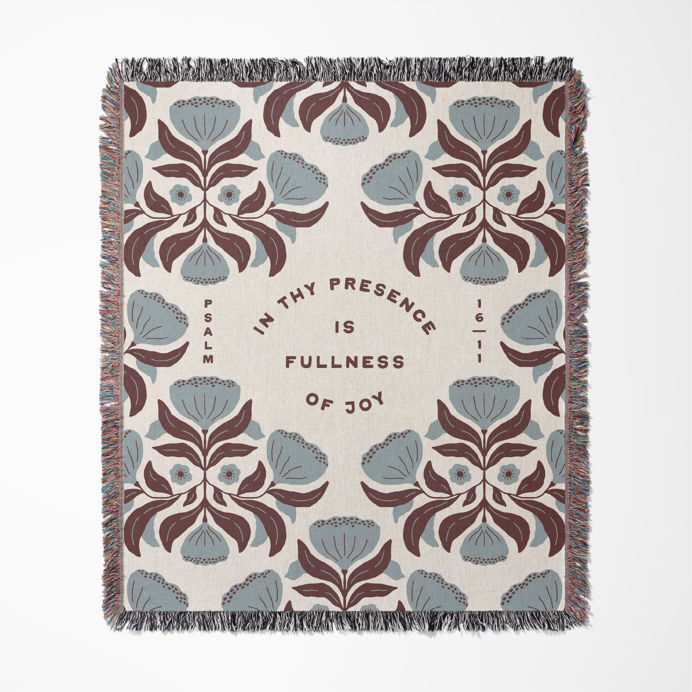 Decorative throw blanket with floral patterns and text on a white background