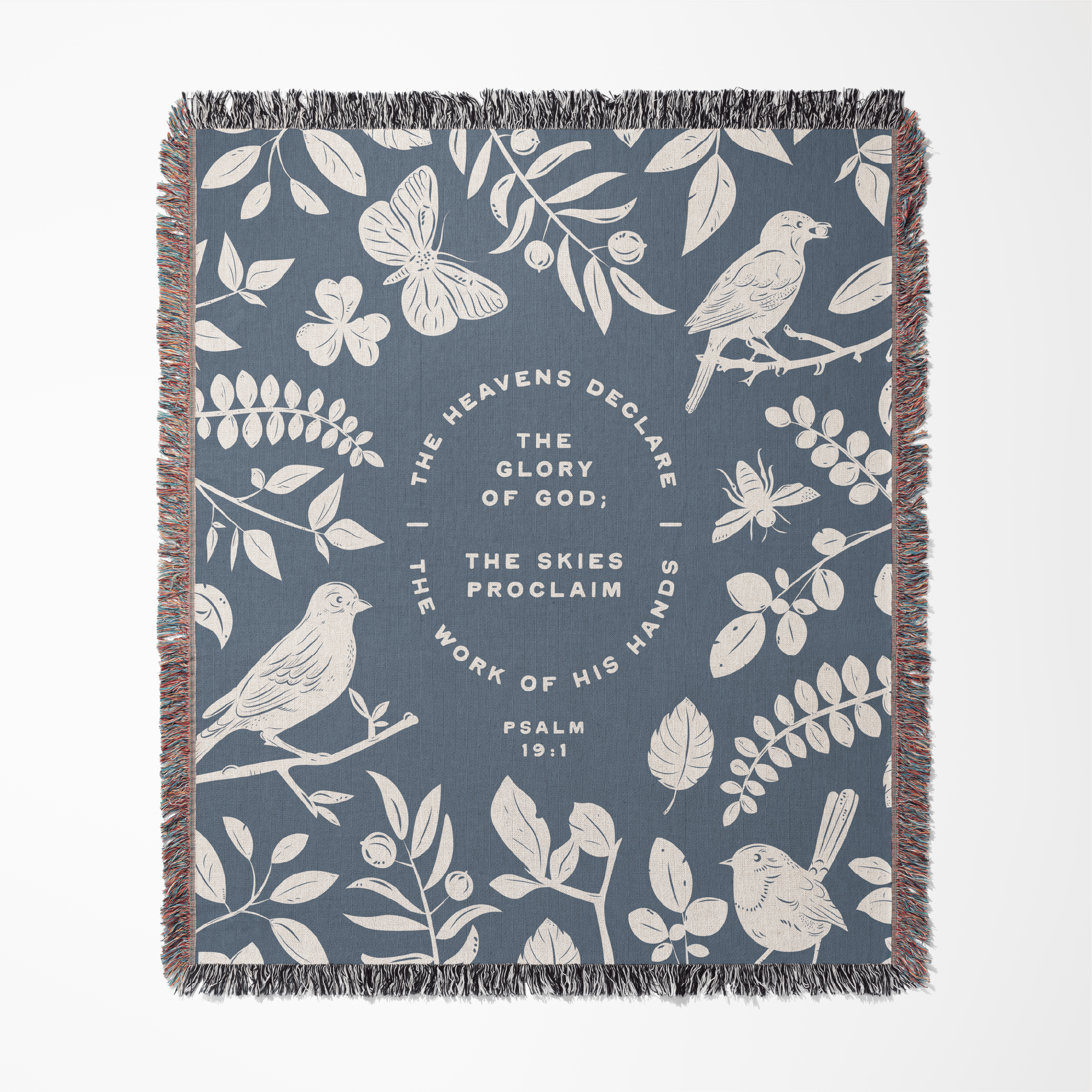 Decorative blanket with nature-themed design and biblical text on a blue background