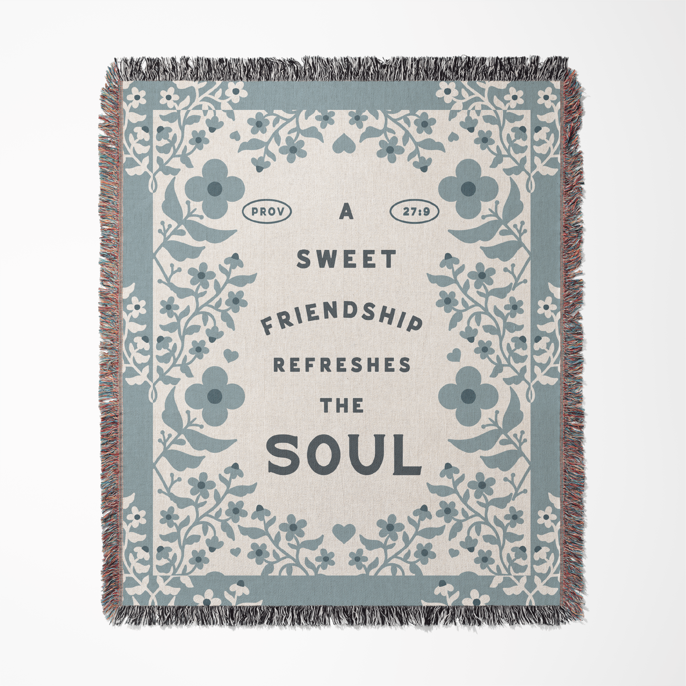 Floral patterned blanket with text 'A sweet friendship refreshes the soul' on a white background