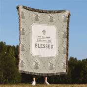 Blanket with 'Blessed' text and floral patterns in a natural setting