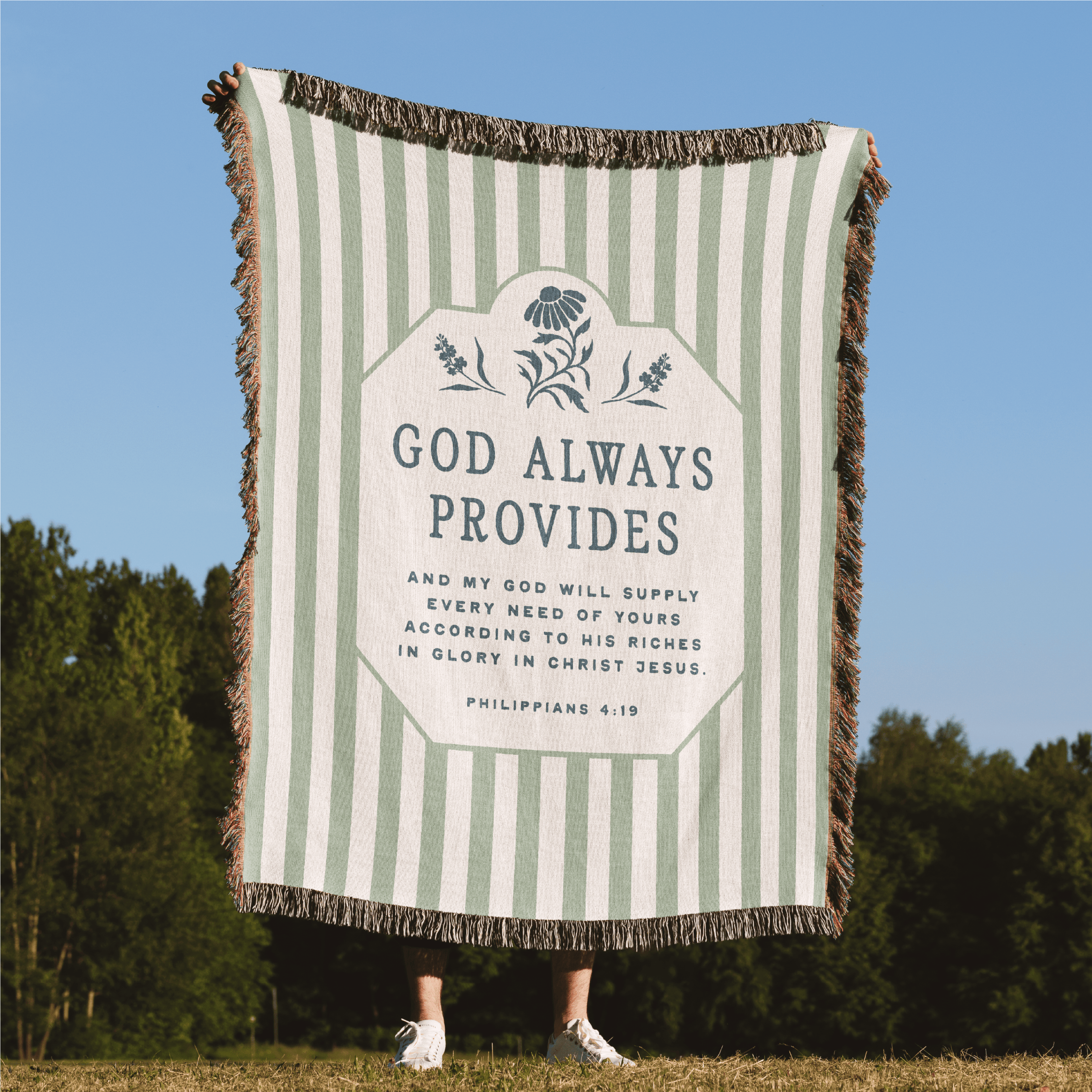 Striped blanket with motivational quote in a field