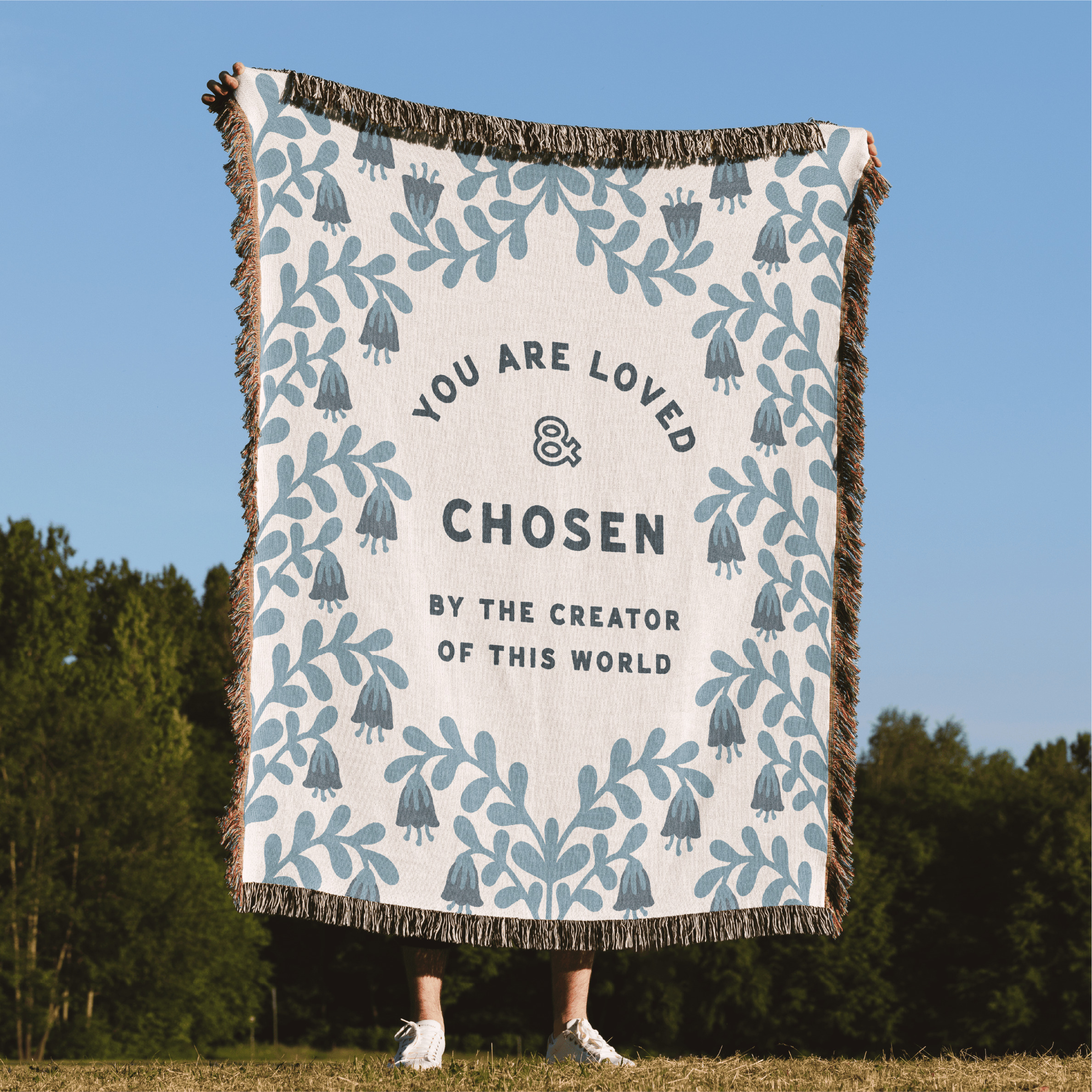 Blanket with motivational text and patterns in a natural setting