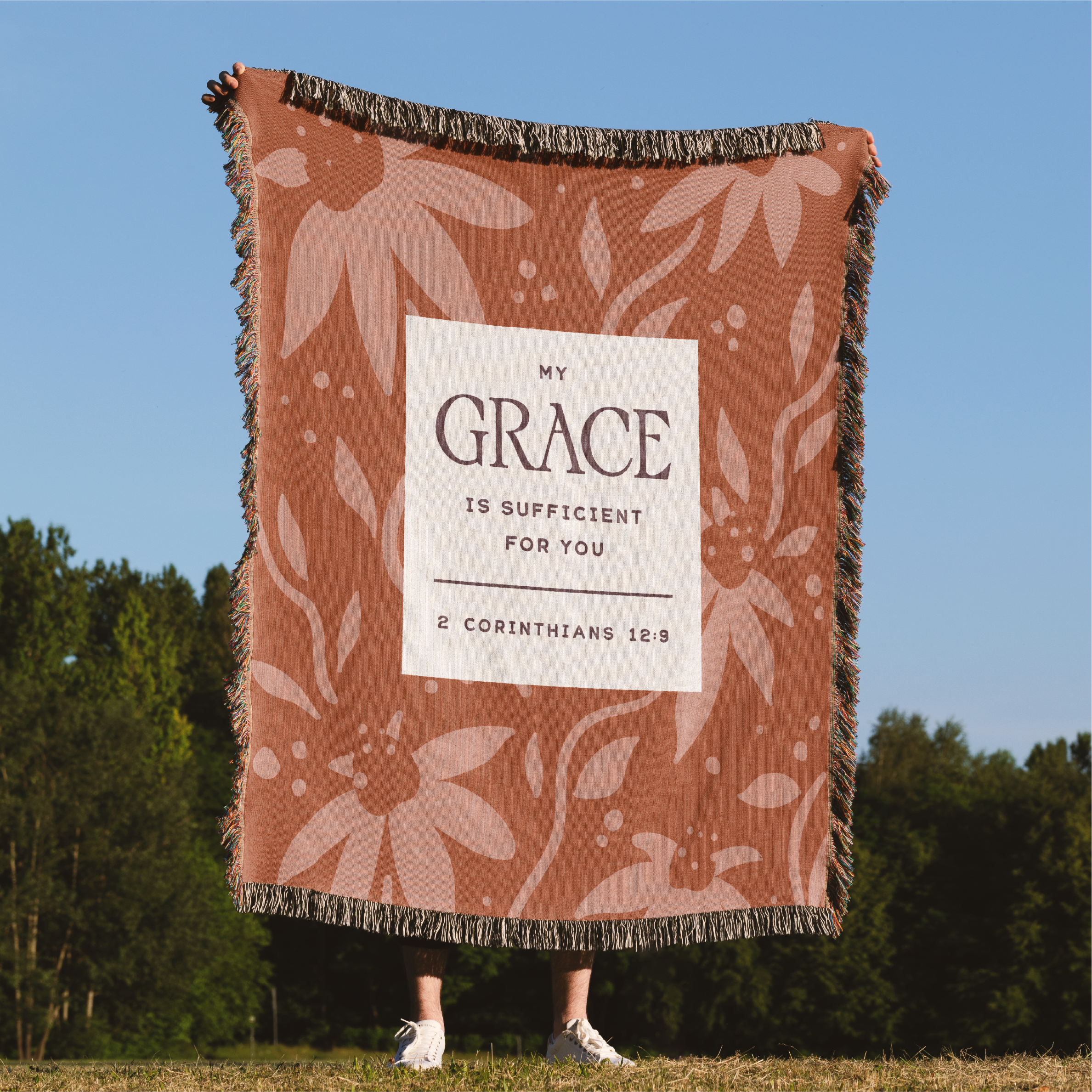 Blanket with 'My Grace is Sufficient for You' text against a natural background
