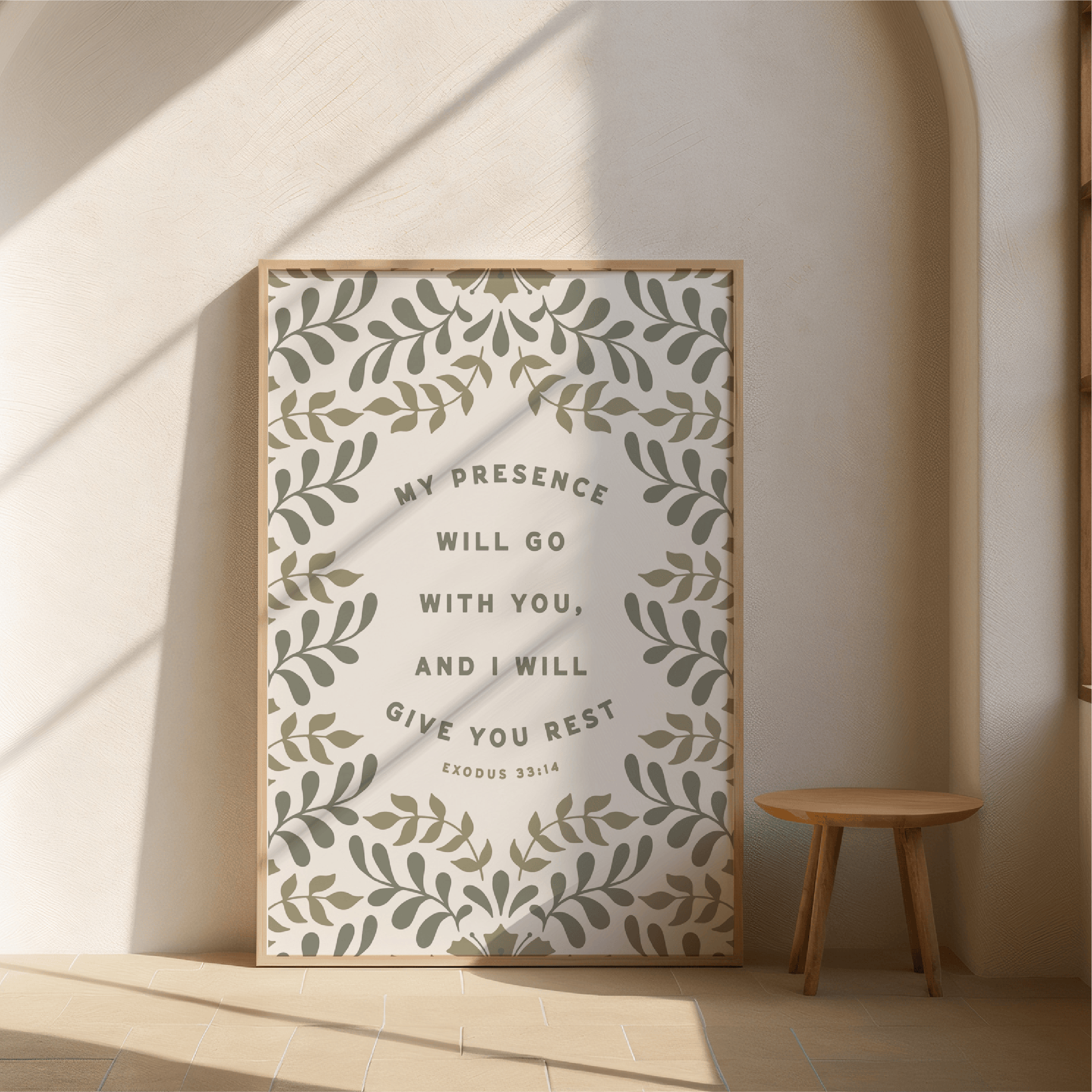 Framed artwork with motivational quote on a wall with a wooden stool below