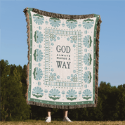 Blanket with 'God always makes a way' text in a scenic outdoor setting