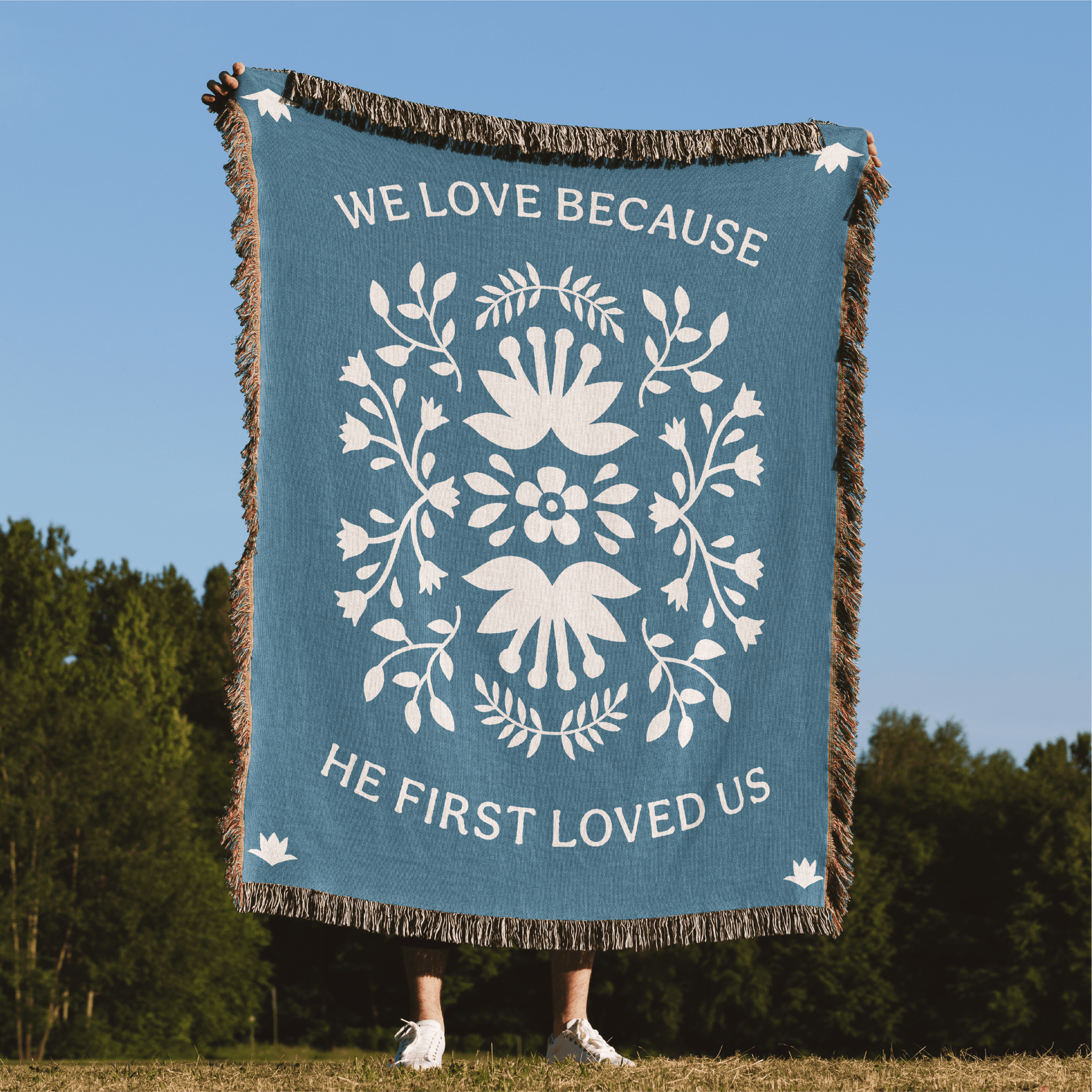 Blanket with decorative design and text in a natural setting