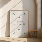 Framed poster with 'Steady in His Care' text in a minimalistic room with a wooden stool.