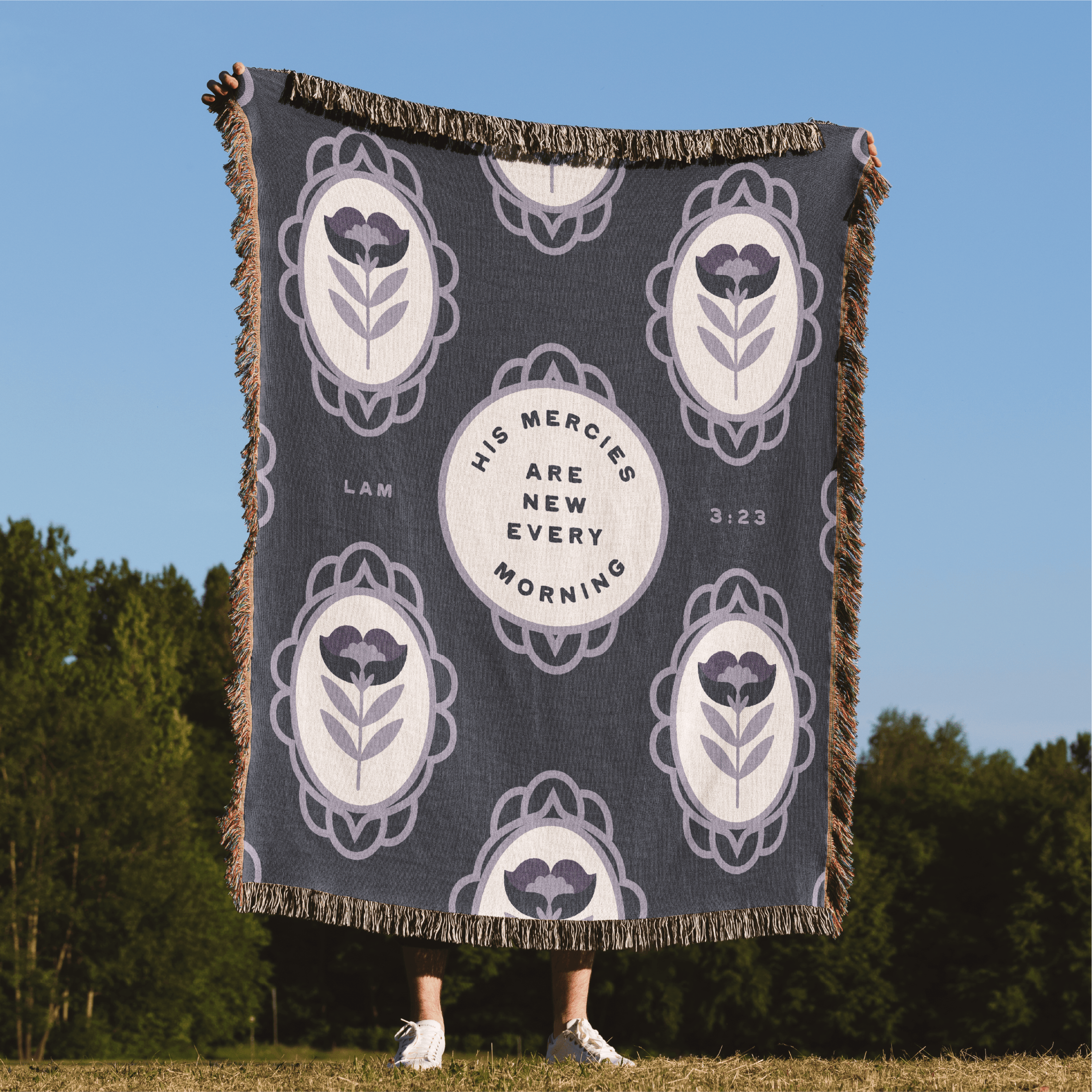 Blanket with floral patterns and text in a natural setting