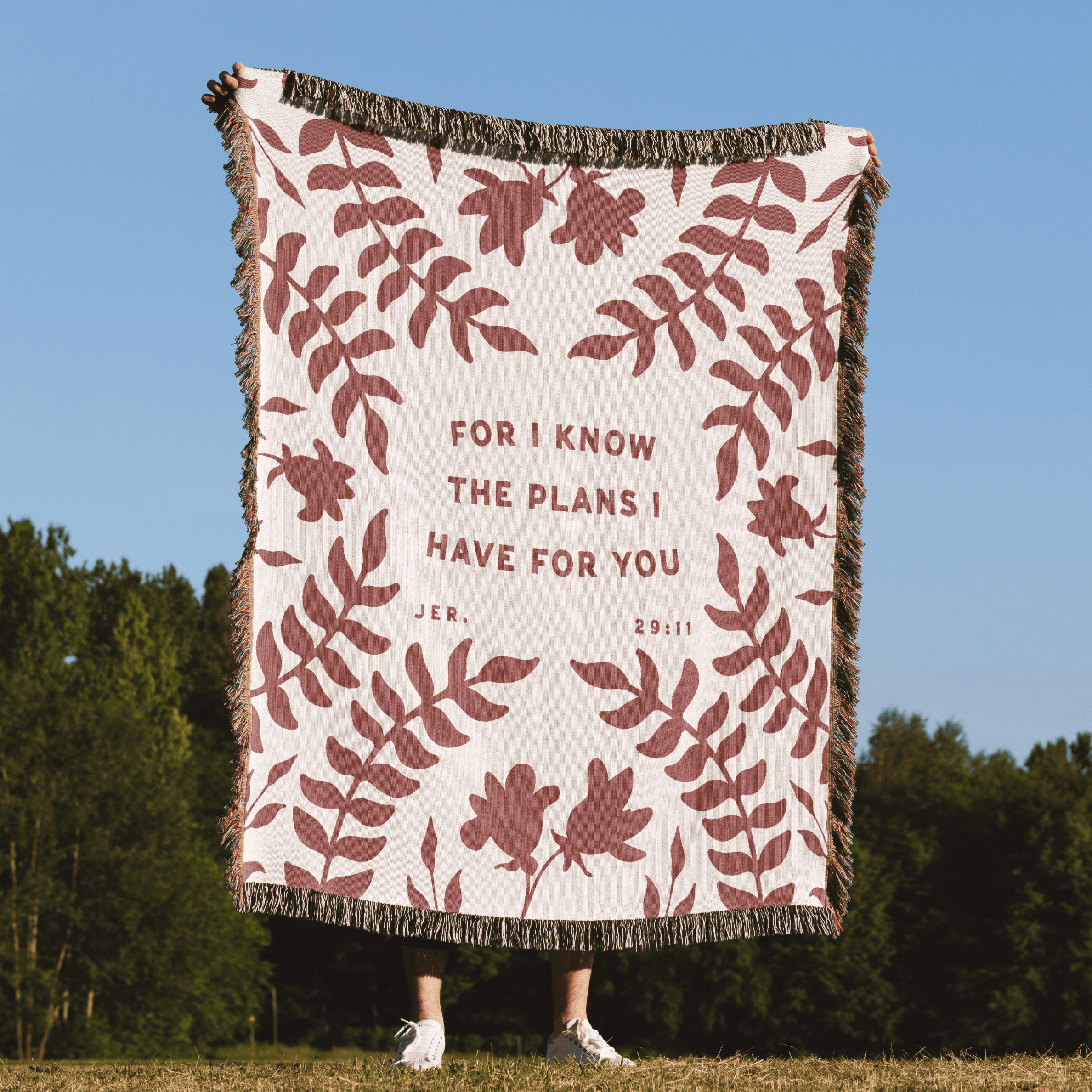 Blanket with floral pattern and text in a natural setting