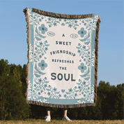 Blanket with floral design and text in a natural setting