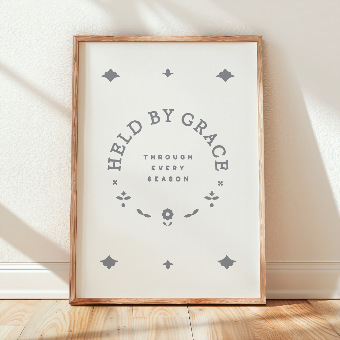Framed print with 'Held by Grace, Through Every Season' text on a white background