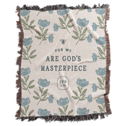 Blanket with floral pattern and text 'For we are God's masterpiece' on a white background