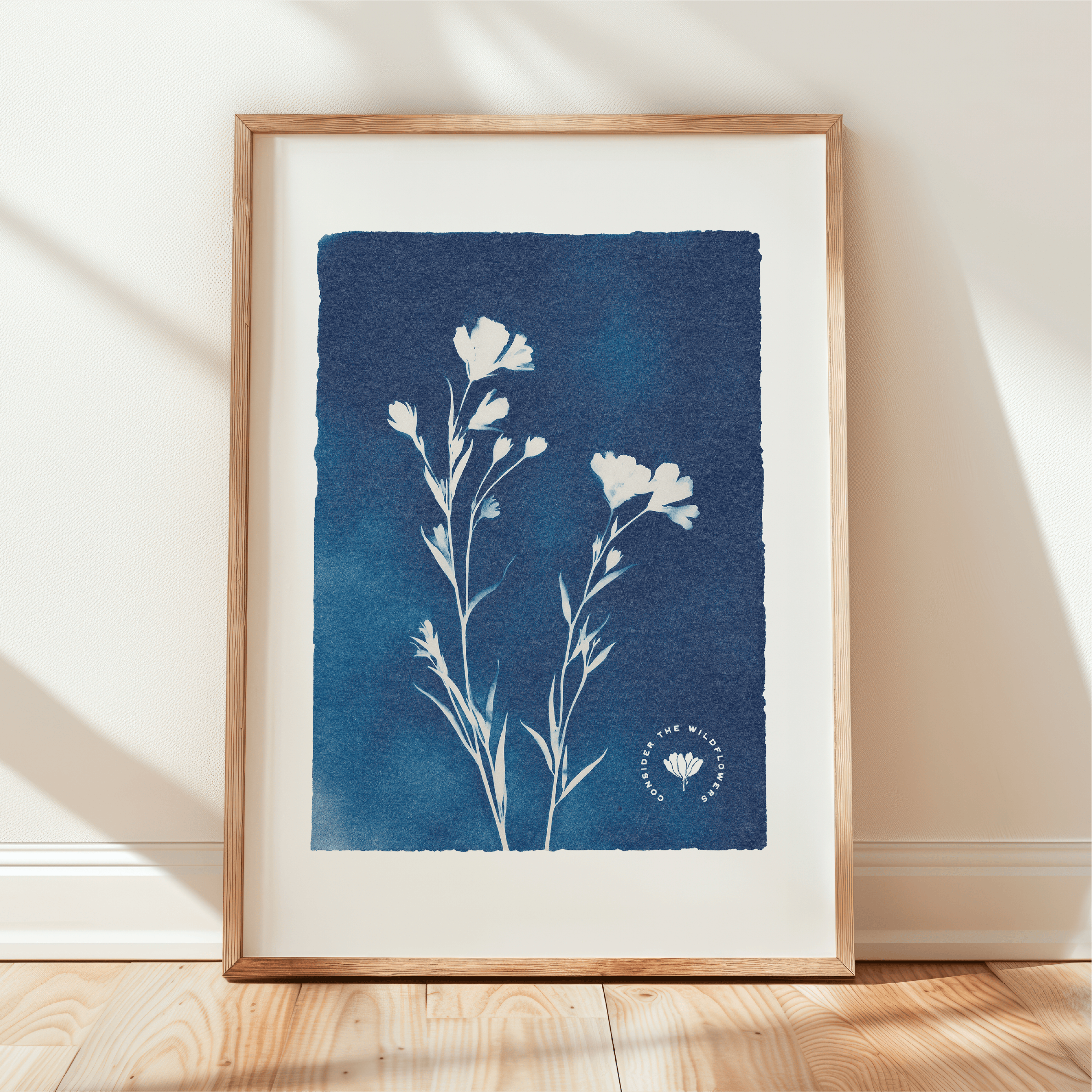 Framed artwork with blue floral design on a white wall