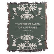 Green blanket with white floral patterns and motivational text on a white background