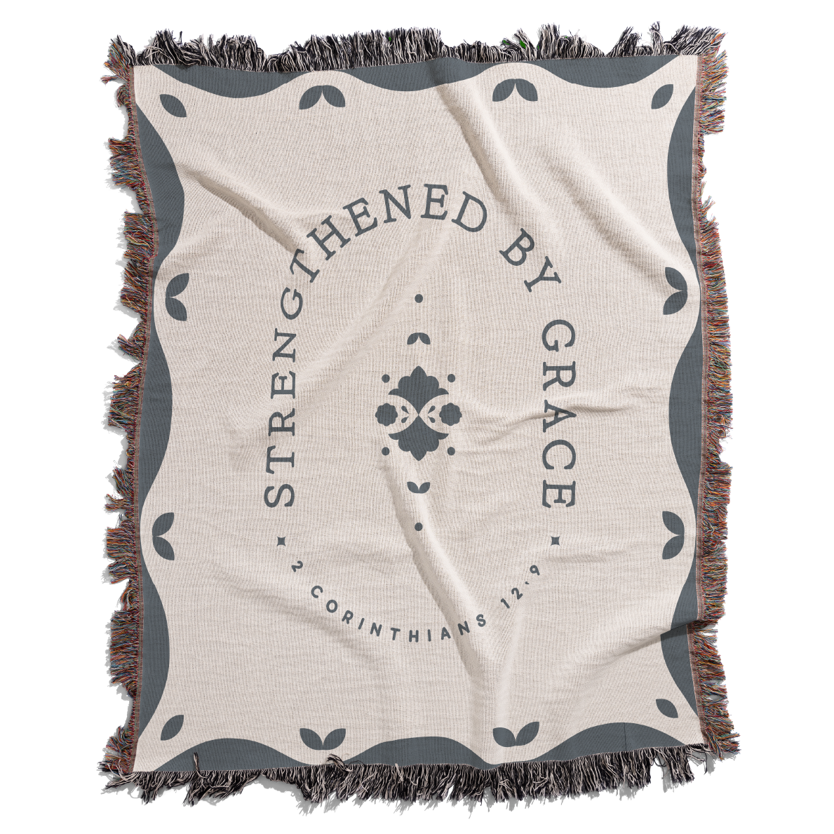 Blanket with 'Strengthened by Grace' text and decorative border on a white background