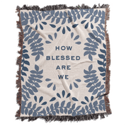 Blanket with blue leaf pattern and 'How blessed are we' text on a white background
